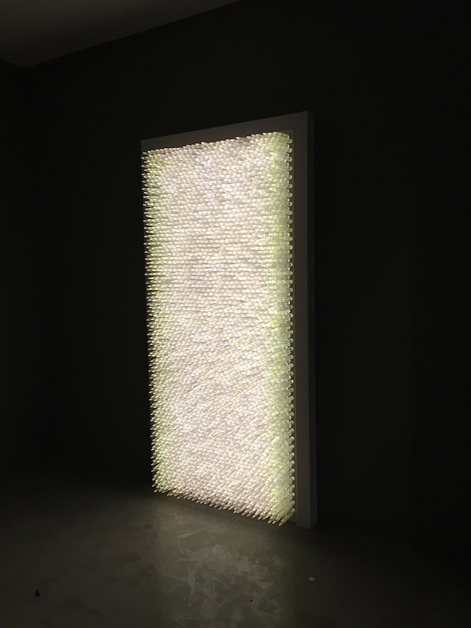 Pandora 2016; LED lightbox within doorframe; clear cast resin 50. cal Browning bullets; installation view, Akbank Sanat, Istanbul 2018